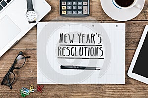 Text new years`s resolutions on note, Office desk with computer